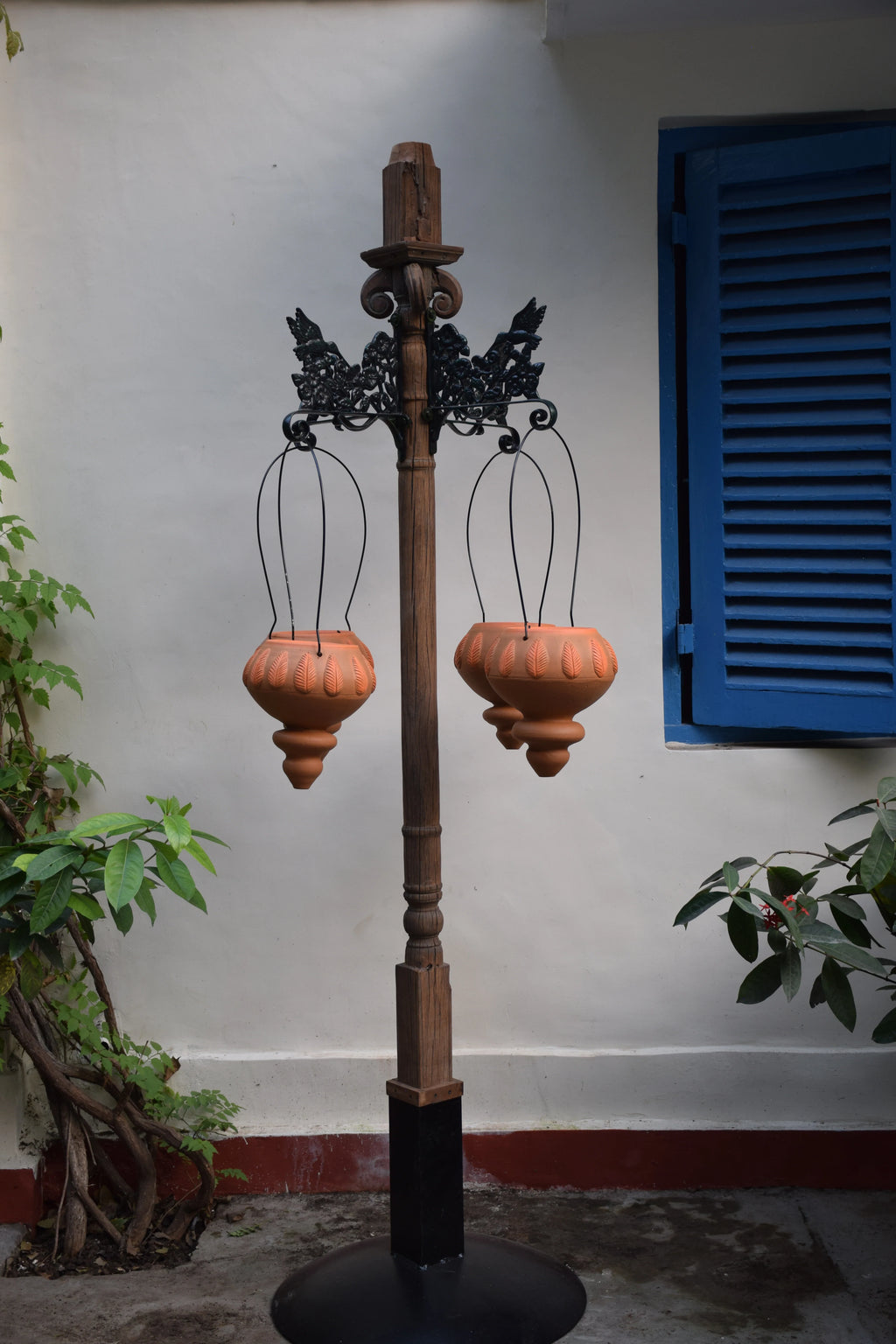 Free standing pillar with wooden planter at the base and brackes for hanging baskets