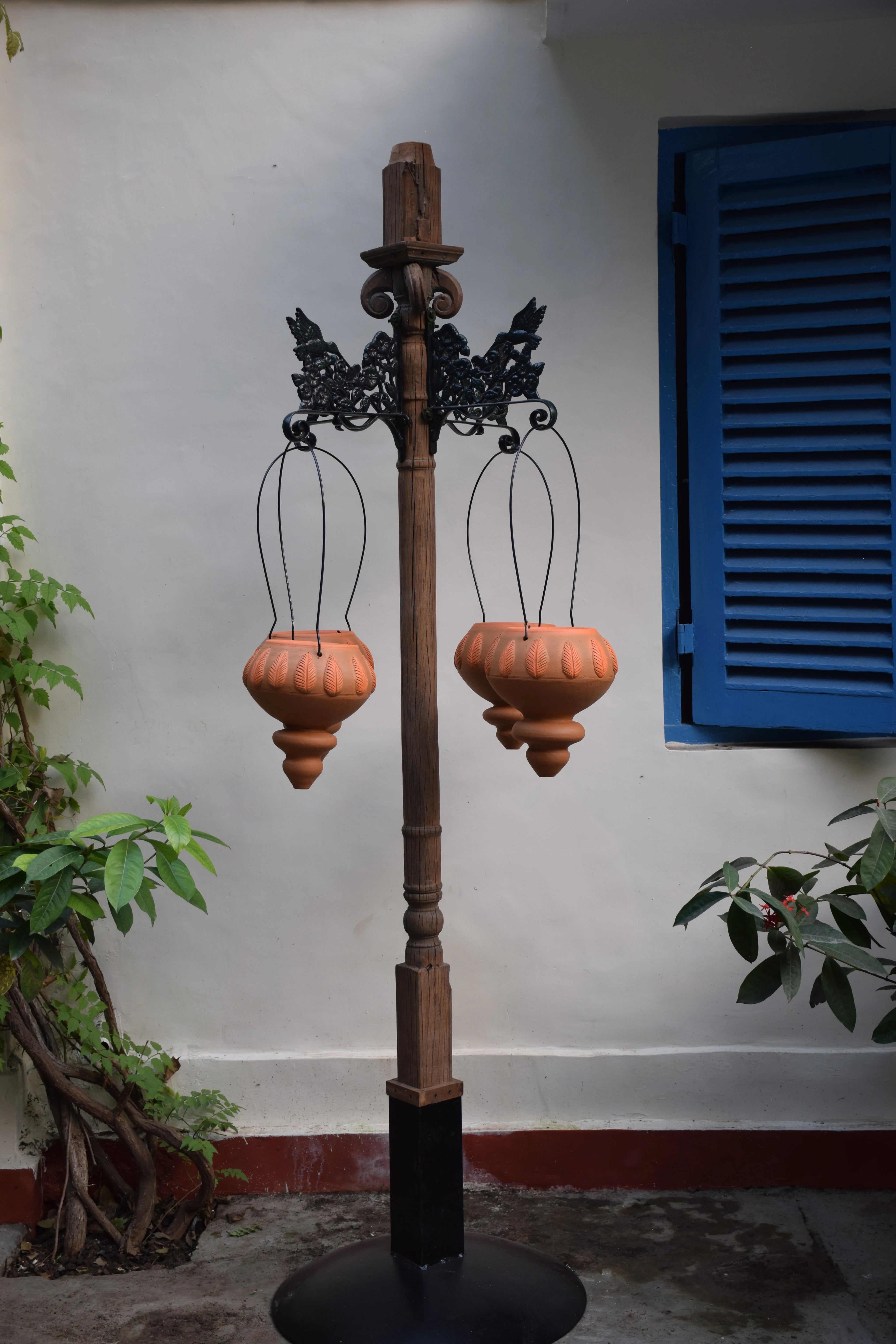 Free standing pillar with wooden planter at the base and brackes for hanging baskets